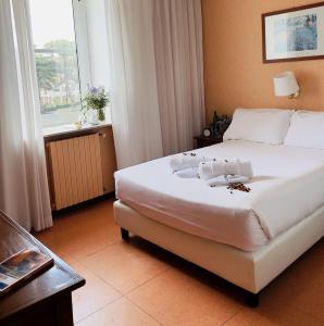 罗马EUR松树公园别墅酒店的卧室配有一张大白色床和窗户