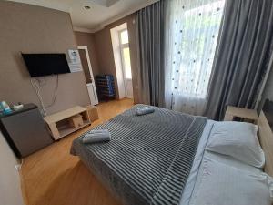 阿哈尔齐赫Guest House "AKHALTSIKHE"的一间卧室设有一张床和一个大窗户