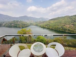 比姆塔尔The Lake Ambience Resort的阳台配有两把椅子,享有河景