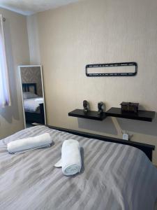 索利赫尔Stylish 4-Bedroom House near NEC/BHX的一间卧室配有一张床,上面有两条毛巾