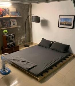 胡志明市The Vinyl Homestay的配有风扇和灯的客房内的一张床位