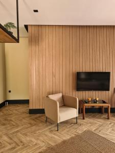 凯麦尔Metavilla的客厅配有椅子和墙上的电视