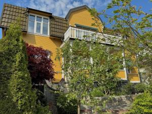 摩尔比兰加Hotell Magasin 1的黄色的房子,上面设有阳台