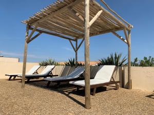 阿格德角Hôtel Bellevue Cap d'Agde的海滩木制凉亭下的2把躺椅