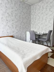 布罗瓦里Hotel Vesta的卧室配有一张床和一张桌子及椅子