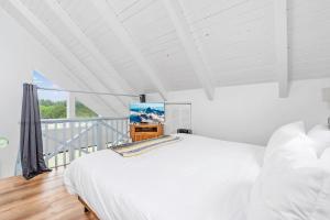 洋滨市Tidal House 2的一间白色卧室,配有床和电视