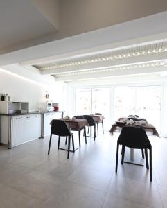 特罗佩阿B&B Sunlight Tropea的一间白色的厨房,内设桌椅
