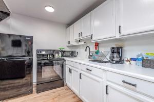 洋滨市Tidal House 3的白色的厨房配有白色橱柜和电器