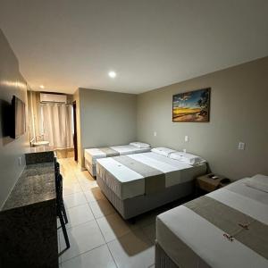 劳鲁-迪弗雷塔斯奥尼克斯机场酒店的酒店客房设有三张床和电视。