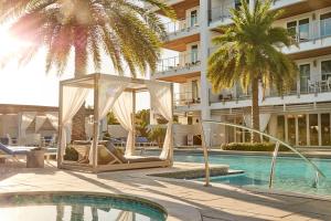 罗斯玛丽海滩Texas Two Step的酒店游泳池设有凉亭,种植了棕榈树。