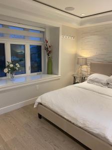 温哥华溫西Ubc如悅民宿的一间卧室设有一张床和一个鲜花窗口