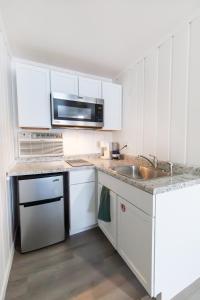 桑达斯基Anchor Bay Inn and Suites的白色的厨房配有水槽和微波炉