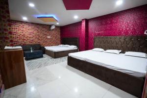 德奥加尔Parinay Vatika Inn的一间卧室设有两张床和红色的墙壁