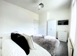 伯恩利Burnley Lebanon House By Bevolve的白色卧室配有带黑色枕头的床