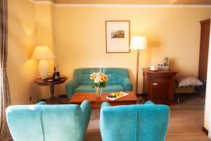 奥帕提亚BRISTOL Hotel Opatija的客厅配有蓝色的沙发和椅子
