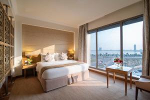 达曼达曼滨海金色郁金香酒店的酒店客房设有一张床和一个大窗户