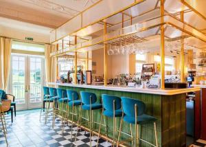 布里奇诺斯The Astbury Golf And Lodge Resort的餐厅内带蓝色椅子的酒吧