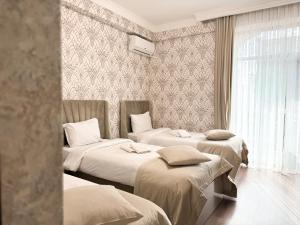 埃里温Armenia Hotel的带三张床和窗户的客房