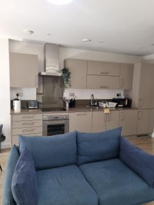 伦敦Stunning 2-Bed Apartment in London的客厅设有蓝色沙发,厨房设有