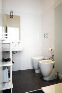 卡利亚里卡利亚里I'MC IoAMo旅馆的一间带卫生间、水槽和镜子的浴室