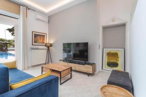 波利克罗诺Albero Villa Polychrono的客厅配有蓝色的沙发和电视