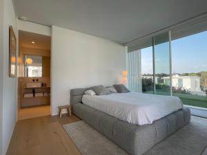 卡尔德斯德马拉维亚Holiday Rentals at Camiral Golf & Wellness的一间卧室设有一张床和一个大窗户