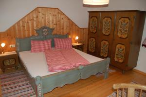 塔克森巴赫Großberghof的一间卧室配有一张带红色枕头的床