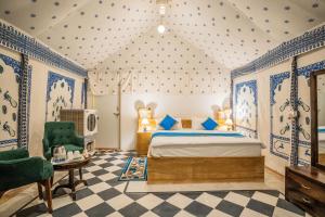 斋沙默尔Desert Heritage Luxury Camp And Resort的一间卧室配有一张特大号床和一把椅子