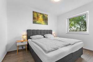 WiefelstedeNiewoh Ferienhaus Wiesenblick,Ammerland, Conneforde的白色的卧室设有一张大床和一个窗户