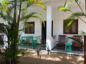阿鲁甘湾Moxy Bay Arugambay的一个带桌椅的庭院和棕榈树