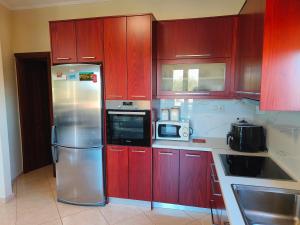 GalangádhosPazinos/Neveli Cottage的厨房配有红色橱柜和不锈钢冰箱