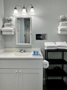 韦尔弗利特The Even'tide的浴室配有盥洗盆、镜子和毛巾