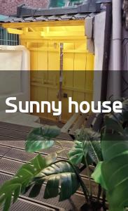 首尔Sunny House的黄色的房子,上面写着阳光明媚的字眼