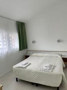 布雷诺花园酒店的一间卧室配有床和绿帘
