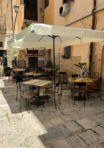 巴勒莫Cortile dei Giusti - Combo Guesthouse的一个带桌椅和遮阳伞的庭院