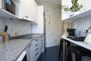 马德里Live It Madrid Chamberi的厨房配有白色橱柜和黑色地板