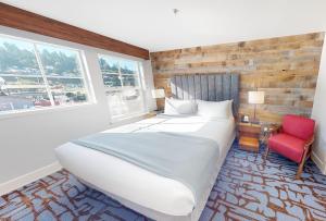 阿斯托里亚Cannery Pier Hotel & Spa的一间卧室配有一张大床和一张红色椅子