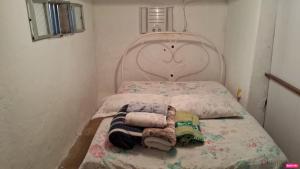 里约热内卢Espaço Aconchegante Na Ilha de Paquetá的一间小卧室,配有一张带大床头板的床
