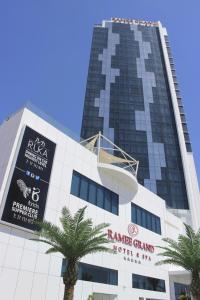麦纳麦拉米Spa大酒店的一座高大的建筑,前面有棕榈树