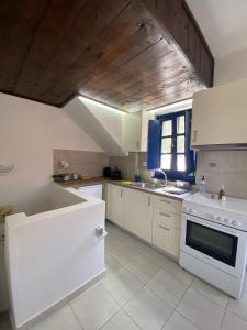 伊兹拉Oros Eros的一间厨房,配有白色家电和木制天花板