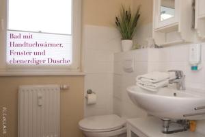 普雷罗Ferienwohnung Strandgut的白色的浴室设有水槽和卫生间。