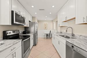 西耶斯塔岛Island House Beach Resort 15N的厨房配有白色橱柜和不锈钢用具
