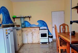 南圣胡安Hostel Rossy的厨房配有桌子、炉灶和冰箱。