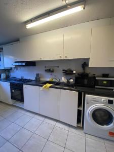 伦敦BUCKINGHAM的厨房配有白色橱柜和洗衣机。