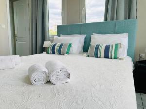 MonoliaSea Breeze Apartments Chios的一间卧室配有带毛巾的床