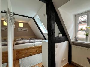 代特莫尔德Wohnen auf der historischen Stadtmauer im Herzen von Detmold的小型阁楼卧室设有1张床和1扇窗户。