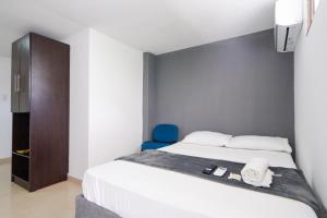 巴兰基亚Hotel Imperial House的一间卧室配有一张床和一张蓝色椅子