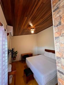 格拉纳达Hotel Mirna & OCT的一间卧室设有一张床和石墙
