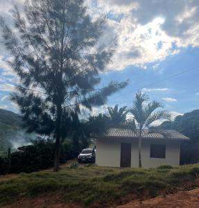 Presidente SoaresCasa de campo的一座白色的房子,旁边停着一辆汽车