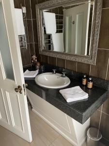 格伦贝赫Towers Hotel Glenbeigh的一间带水槽和镜子的浴室